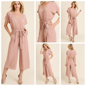 Wide leg crop, v-neck jumpsuit in pale pink.